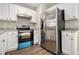 White cabinets and stainless steel appliances furnish this kitchen with grey countertops and wood-look flooring at 1534 Norman Xing, Atlanta, GA 30349