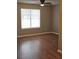 Bright bedroom with ceiling fan, light walls, and beautiful, dark laminate wood flooring at 4233 Viewpoint Ln, Ellenwood, GA 30294