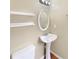 Bathroom featuring a pedestal sink, an oval mirror, and white decorative shelves at 155 Mine Run, Fayetteville, GA 30215