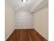 Cozy bedroom featuring hardwood floors and an attractive accent wall at 155 Mine Run, Fayetteville, GA 30215
