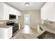 Charming kitchen with granite countertops, white cabinets, and stainless steel appliances at 155 Mine Run, Fayetteville, GA 30215