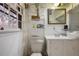 Modest bathroom with a toilet, sink, mirror, and a window providing natural light at 3948 Bright Star Rd, Douglasville, GA 30135