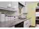 Close-up of a kitchen sink with white cabinets and granite countertops with colorful decor at 3948 Bright Star Rd, Douglasville, GA 30135