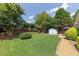 Lush backyard with a well-manicured lawn, privacy fence, storage shed, and patio area at 142 Carl Barrett Dr, Canton, GA 30115