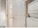 Laundry room area with door leading to hallway featuring a stacked washer and dryer unit at 2201 Stratford Commons, Decatur, GA 30033