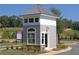 Community gatehouse surrounded by landscaping and lush trees at 1209 Lakeside Overlook, Canton, GA 30114