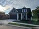 Charming home with gray siding, a covered porch with stone supports, and a two-car garage at 1209 Lakeside Overlook, Canton, GA 30114