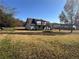 Spacious backyard featuring a deck with stairs, mature trees, and level lawn at 1350 Cedars Rd, Lawrenceville, GA 30045