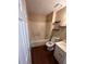 Bright bathroom featuring a shower/tub combo, a vanity, and a toilet with shelving at 1350 Cedars Rd, Lawrenceville, GA 30045