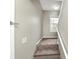 Carpeted staircase leading to the upper level, accented by a bright window at 6422 Pinebark Way, Morrow, GA 30260