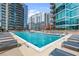 Community pool with city views, lounge chairs, tables and seating with umbrellas at 1080 Peachtree Ne St # 2108, Atlanta, GA 30309