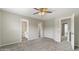 Bright bedroom with neutral paint, carpet, and a ceiling fan, with open doorways and a view to the hall and bathroom at 1202 Charleston Ct Cir, Woodstock, GA 30188