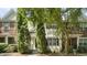 Charming townhome featuring a mix of brick and siding, complemented by mature trees and well-maintained landscaping at 1202 Charleston Ct Cir, Woodstock, GA 30188
