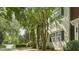 A lush tree partially obscures a charming two-story home with black shutters on the windows at 1202 Charleston Ct Cir, Woodstock, GA 30188