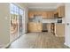 A bright kitchen with modern appliances, light wood cabinets, and a sliding glass door out to the patio at 1202 Charleston Ct Cir, Woodstock, GA 30188