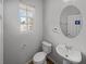 Charming powder room with a pedestal sink, oval mirror, and natural light from the window at 3972 Carlinswood Way, Stone Mountain, GA 30083
