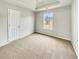 Bedroom featuring a tray ceiling, neutral carpet, a double door closet, and a bright window at 3414 Bench Ave, Atlanta, GA 30349