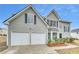 Two-story home featuring a two-car garage, tidy lawn, and well-maintained landscaping at 3414 Bench Ave, Atlanta, GA 30349