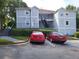 A bright two-story apartment building with two cars parked in front showcasing ample parking space at 4275 Orchard Grove, Stone Mountain, GA 30083