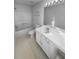 Well-lit bathroom with white vanity, large mirror, shower-tub combo, and tile flooring at 61 Barrington Pl, Marietta, GA 30066