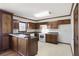 Traditional kitchen featuring wood cabinets, white appliances, and neutral countertops at 1526 Fernbrook Sw Ct, Lilburn, GA 30047