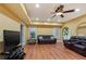 Open basement living room with hardwood floors, ceiling fan, recessed lighting, and dark leather sofas at 3130 Kates Nw Way, Kennesaw, GA 30152