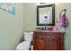 Charming powder room with a wooden vanity, granite countertop, and decorative mirror at 3130 Kates Nw Way, Kennesaw, GA 30152