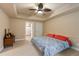 Carpeted bedroom with ceiling fan, tray ceiling, natural light, and ensuite bathroom at 3130 Kates Nw Way, Kennesaw, GA 30152