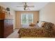 Neutral bedroom with ceiling fan and bed with colorful patterned quilt at 3130 Kates Nw Way, Kennesaw, GA 30152