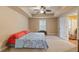 Carpeted bedroom with ceiling fan, tray ceiling, and natural light from the windows at 3130 Kates Nw Way, Kennesaw, GA 30152