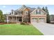 Charming two-story home with stone accents, a manicured lawn, and a two-car garage at 3130 Kates Nw Way, Kennesaw, GA 30152