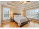 Bright main bedroom featuring tray ceilings, hardwood floors, and large windows at 3130 Kates Nw Way, Kennesaw, GA 30152