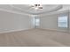 Spacious main bedroom with neutral carpet, tray ceiling, fan, and plenty of natural light at 3808 The Great Dr, Atlanta, GA 30349