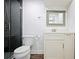 Modern bathroom featuring a glass shower with dark tile and a vanity with a framed mirror at 4085 Amberly Nw Grn, Kennesaw, GA 30144