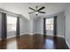 A bedroom with two large windows, hardwood floors, and ceiling fan at 4085 Amberly Nw Grn, Kennesaw, GA 30144