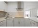 A modern kitchen with white cabinets, stainless steel range hood, and stone countertops at 4085 Amberly Nw Grn, Kennesaw, GA 30144