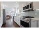 Stylish kitchen features stainless steel appliances, white cabinets, white countertops, and hardwood floors at 4085 Amberly Nw Grn, Kennesaw, GA 30144