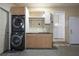 Laundry room with stacked washer/dryer unit, sink, cabinets, and exterior door at 4085 Amberly Nw Grn, Kennesaw, GA 30144
