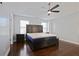 Spacious main bedroom featuring a dark wood bed frame, hardwood floors, and a ceiling fan at 4085 Amberly Nw Grn, Kennesaw, GA 30144