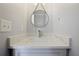 Powder room with modern mirror, granite countertop, white cabinetry, and stainless steel faucet at 4085 Amberly Nw Grn, Kennesaw, GA 30144