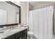 Modern bathroom with a granite countertop vanity, white waffle shower curtain, and a mirror at 6304 Long Island Drive, Sandy Springs, GA 30328