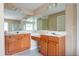 Bathroom featuring double sinks, wooden cabinets, and a large mirror at 3008 Stockbridge Way, Dacula, GA 30019