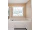 Bright bathroom showcasing a soaking tub and a window with natural lighting at 3008 Stockbridge Way, Dacula, GA 30019