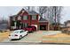 Classic brick home featuring a two car garage, ample parking, and traditional architectural details at 3008 Stockbridge Way, Dacula, GA 30019