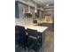 Kitchen area featuring barstool seating, stainless steel appliances, gray cabinets, and modern lighting at 3008 Stockbridge Way, Dacula, GA 30019