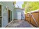 Small backyard patio with siding on the house, a wooden fence, and a white door on a storage room at 485 Lantern Wood Dr, Scottdale, GA 30079