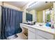 Bathroom featuring a vanity with a single sink, a large mirror, and a shower with a dark shower curtain at 485 Lantern Wood Dr, Scottdale, GA 30079