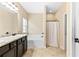 Bright bathroom featuring a shower and bathtub, tiled floors and granite vanity at 11181 Wind Ridge Dr, Hampton, GA 30228