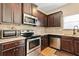 Modern kitchen with stainless steel appliances, dark cabinetry, and granite countertops for meal preparation at 11181 Wind Ridge Dr, Hampton, GA 30228