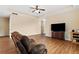 Comfortable living room features laminate floors, a ceiling fan, and modern entertainment setup at 11181 Wind Ridge Dr, Hampton, GA 30228